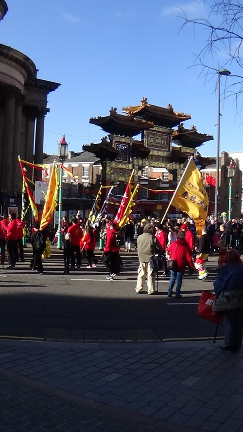 Chinese New Year Liverpool 2016 parade with flags with Chinese Arch in background at entrance to Chinatown 7th February 2016 photo 3
