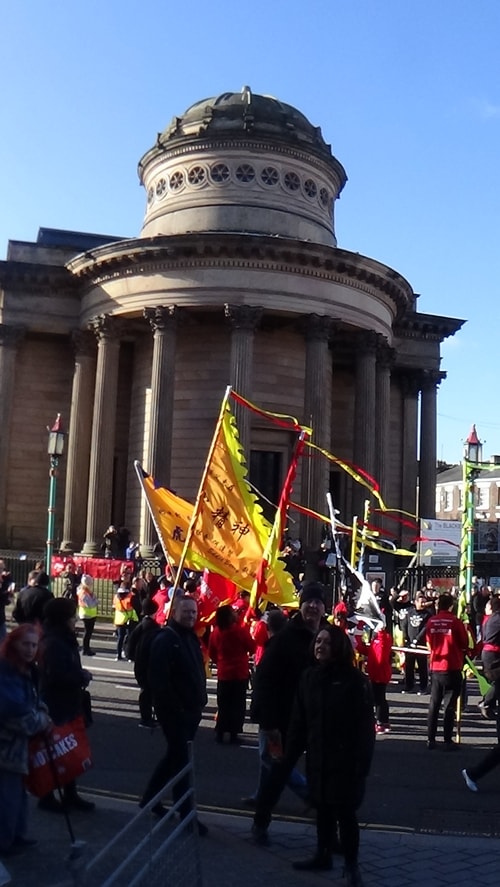 Chinese New Year Liverpool 2016 parade with flags with Chinese Arch in background at entrance to Chinatown 7th February 2016 photo 4