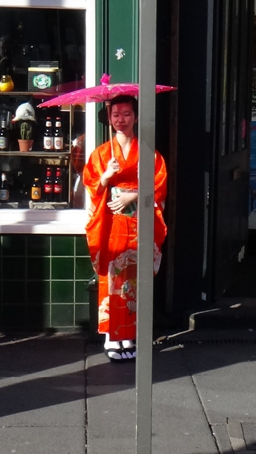 Chinese New Year Liverpool 2016 woman in costume with umbrella outside shop photo 2  7th February 2016